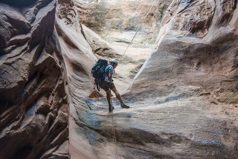 USA, Utah, Moab, Canyonering, Man rapelling down in slot canyon - RUNF01850