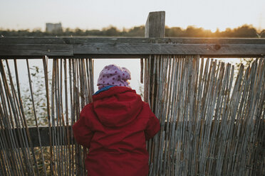 Rear view of toddler girl in warm clothes at a lake - DWF00396