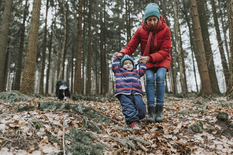 Mutter mit kleiner Tochter und Border Collie im herbstlichen Wald, lizenzfreies Stockfoto