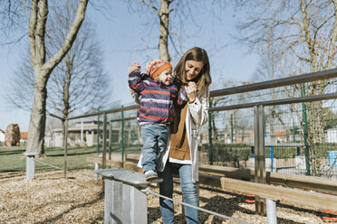 Happy mother with little daughter on a playground - DWF00418