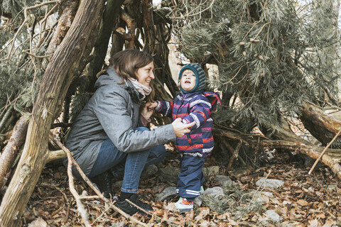 Mutter mit kleiner Tochter in einem Unterstand im Wald, lizenzfreies Stockfoto