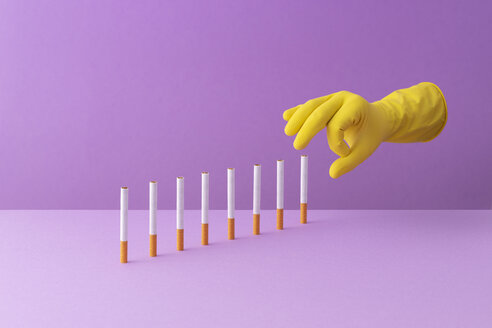 Zigaretten mit der Hand in einer Reihe schieben, wodurch ein Dominoeffekt entsteht - DRBF00150