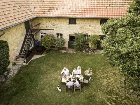 Familie beim gemeinsamen Essen im Garten im Sommer, lizenzfreies Stockfoto