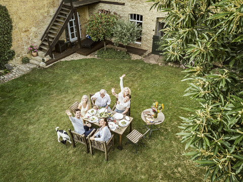 Family eating together in the garden in summer stock photo