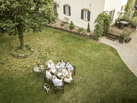 Familie beim gemeinsamen Essen im Garten im Sommer - PESF01560