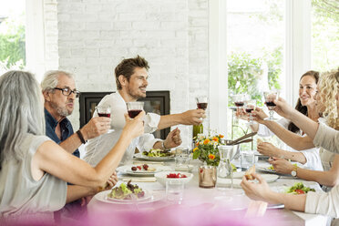 Happy family celebrating together, clinking glasses - PESF01592
