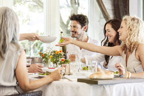 Glückliche Familie, die gemeinsam feiert und auf die Gläser anstößt, lizenzfreies Stockfoto