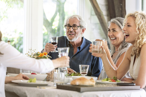 Happy family celebrating together, clinking glasses stock photo