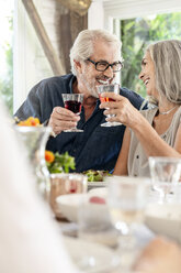 Ein älteres Paar feiert mit seiner Familie und stößt mit ihr an - PESF01601