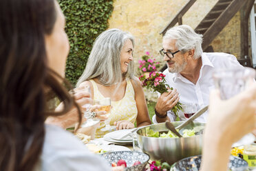 Glückliche Familie beim gemeinsamen Essen im Garten - PESF01646