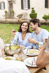 Glückliche Familie beim gemeinsamen Essen im Garten - PESF01648