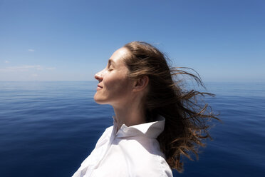 Seychelles, Indian Ocean, profile of woman on ferry enjoying breeze - NDF00907