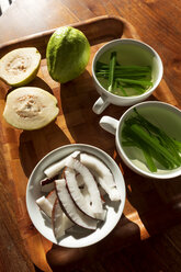Seychellen, Holztablett mit Guave, Schale mit frischen Kokosnussscheiben und Tassen mit Zitronengras-Tee - NDF00911