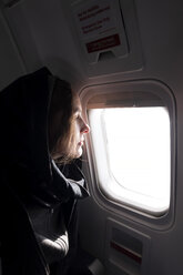 Profil einer Frau im Flugzeug, die aus dem Fenster schaut - NDF00923