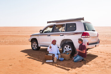 Tourist bei einer Kaffeepause mit seinem einheimischen Fahrer in der Wüste, Wahiba Sands, Oman - WVF01310