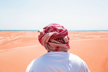 Beduine in Nationaltracht in der Wüste stehend, Rückansicht, Wahiba Sands, Oman - WVF01314