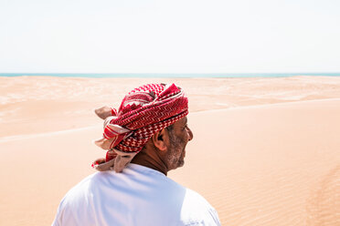 Beduine in Nationaltracht in der Wüste stehend, Rückansicht, Wahiba Sands, Oman - WVF01315