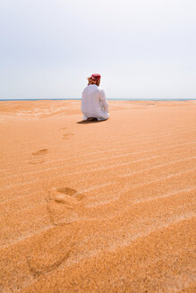 Beduinen in Nationaltracht beim Gebet in der Wüste, Rückansicht, Wahiba Sands, Oman - WVF01317