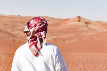 Beduine in Nationaltracht in der Wüste stehend, Rückansicht, Wahiba Sands, Oman - WVF01344