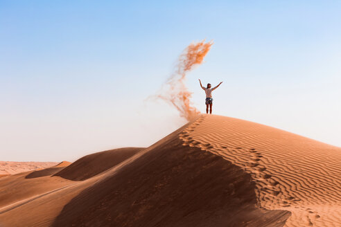 Sultanat Oman, Wahiba Sands, Mittlerer erwachsener Mann spielt mit Sand in der Wüste - WVF01349