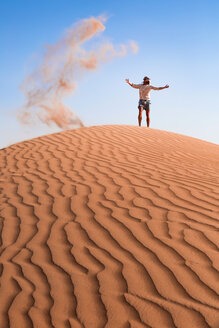 Sultanat Oman, Wahiba Sands, Mittlerer erwachsener Mann spielt mit Sand in der Wüste - WVF01350