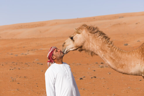 Beduine küsst sein Kamel in der Wüste, Wahiba Sands, Oman - WVF01363