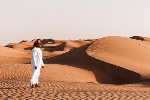 Bedouin in National dress standing in the desert, Wahiba Sands, Oman - WVF01378