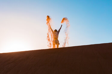 Sultanat Oman, Wahiba Sands, Mittlerer erwachsener Mann spielt mit Sand in der Wüste - WVF01388