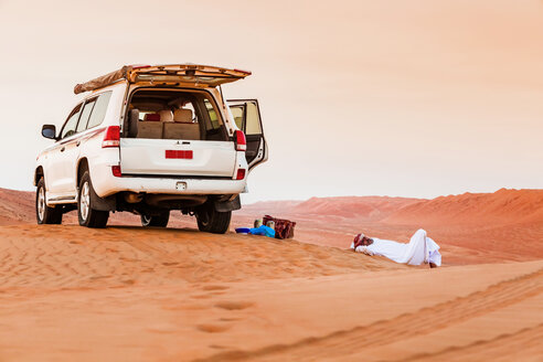 Beduine macht eine Pause neben seinem Auto in der Wüste, Wahiba Sands, Oman - WVF01408