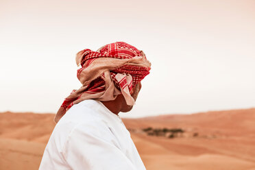 Beduine in Nationaltracht in der Wüste stehend, Rückansicht, Wahiba Sands, Oman - WVF01411