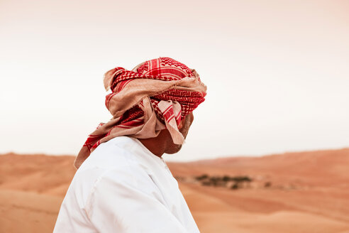 Beduine in Nationaltracht in der Wüste stehend, Rückansicht, Wahiba Sands, Oman - WVF01411