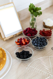 Tablet and fresh fruits in bowls for preparing a cake - GIOF06182