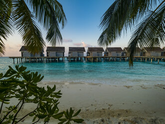 Malediven, Ross Atoll, Wasserbungalows am Strand am Abend - AMF06909