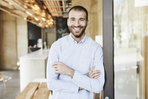 Porträt eines lächelnden Geschäftsmannes in einem modernen Büro, lizenzfreies Stockfoto