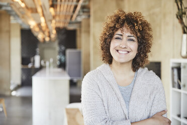 Portrait of smiling woman in modern office - FMKF05551