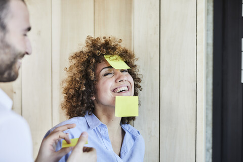 Kollegen im Büro, die ein Brainstorming machen und mit Post-its herumalbern, lizenzfreies Stockfoto