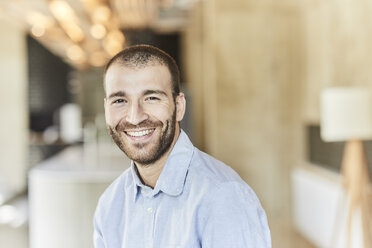 Portrait of happy businessman in modern office - FMKF05588