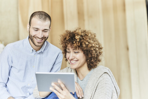 Glücklicher Mann und glückliche Frau teilen sich ein Tablet, lizenzfreies Stockfoto