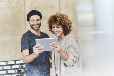 Happy man and woman sharing tablet - FMKF05601