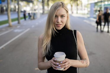 Porträt einer lächelnden blonden Frau mit Kaffee zum Mitnehmen - GIOF06210