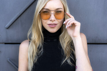 Porträt einer modischen jungen Frau mit Sonnenbrille - GIOF06247