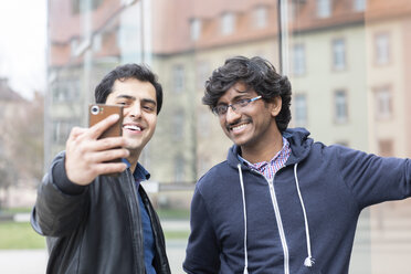 Porträt von lächelnden Freunden, die ein Selfie mit einem Smartphone machen - SGF02366