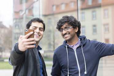 Portrait of smiling friends taking selfie with smartphone - SGF02366