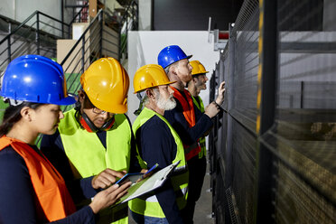 Stehende Arbeiter in einer Fabrikhalle - ZEDF02077