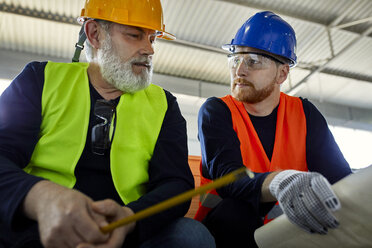 Zwei Männer arbeiten an einem Plan in einer Fabrik - ZEDF02088