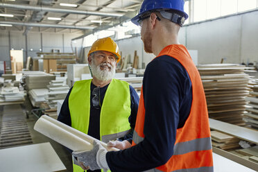 Zwei Männer mit Plan im Gespräch in einer Fabrik - ZEDF02089