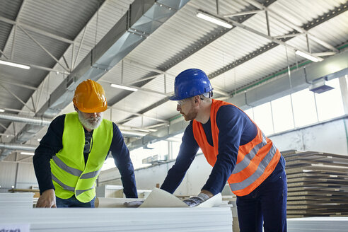 Zwei Männer arbeiten an einem Plan in einer Fabrik - ZEDF02096