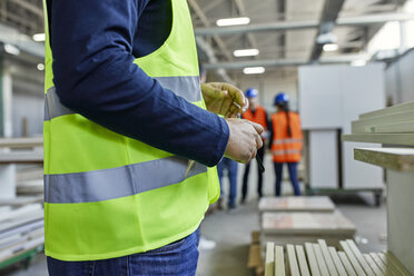 Nahaufnahme eines Arbeiters mit Warnweste in einer Fabrik - ZEDF02099