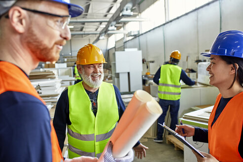 Glückliche Kollegen in Arbeitsschutzkleidung im Gespräch in der Fabrik - ZEDF02106