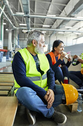 Arbeiter in einer Fabrik machen gemeinsam Mittagspause - ZEDF02135
